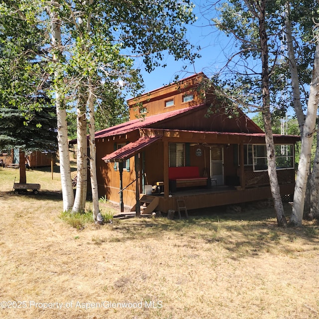 back of house with covered porch and metal roof