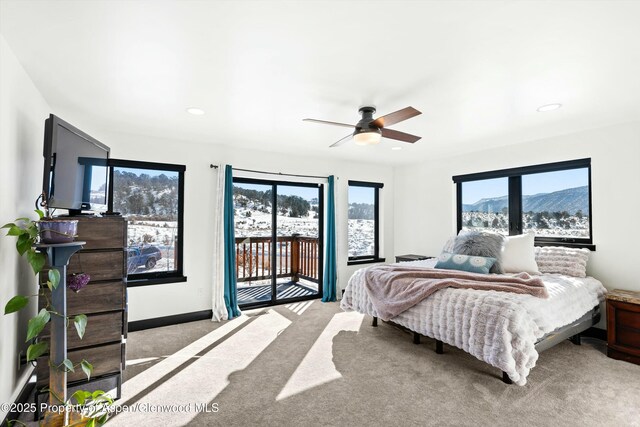 carpeted bedroom with ceiling fan, access to exterior, and a mountain view