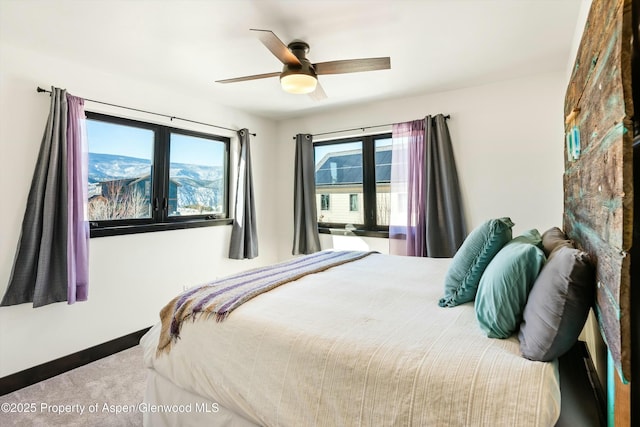 bedroom featuring a mountain view, carpet floors, and ceiling fan