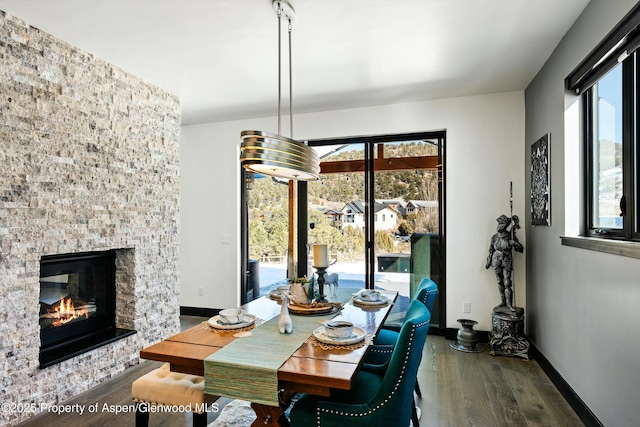 dining space featuring dark hardwood / wood-style flooring and a fireplace