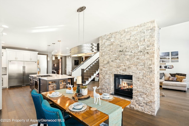 dining room featuring a fireplace and dark wood-type flooring