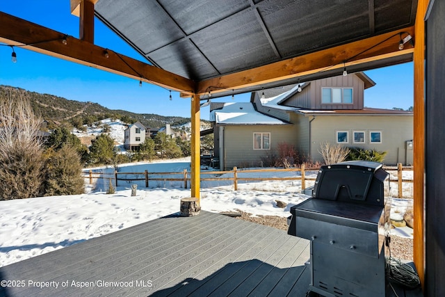 snow covered deck with a mountain view