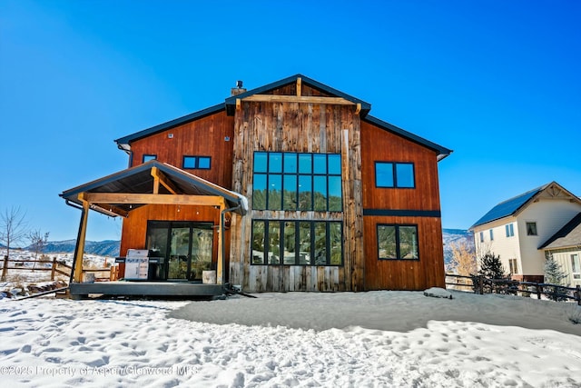 snow covered rear of property with a mountain view