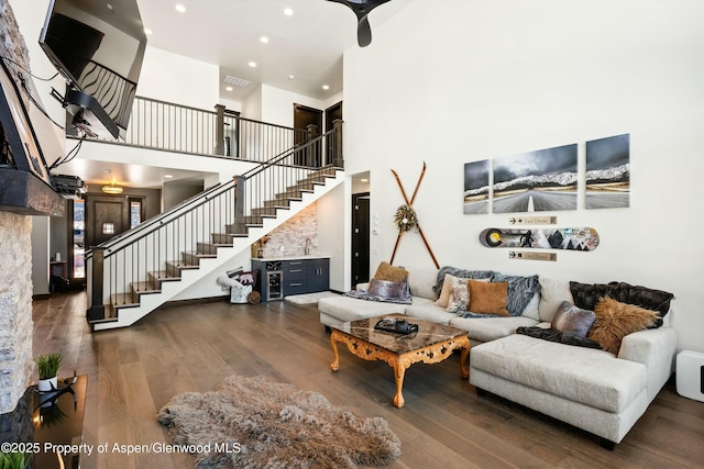 living room featuring a towering ceiling and dark wood-type flooring