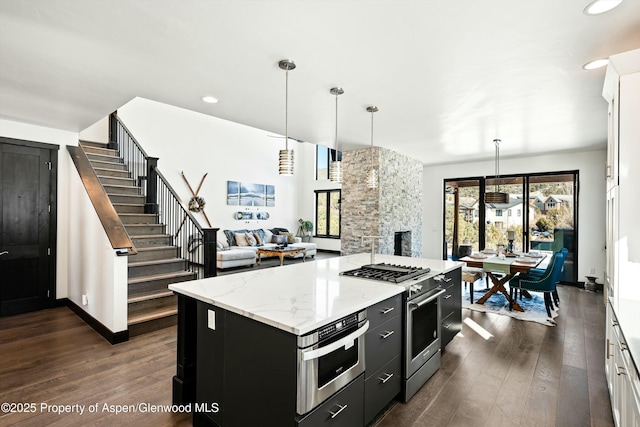 kitchen with white cabinetry, a center island, pendant lighting, and stainless steel stove