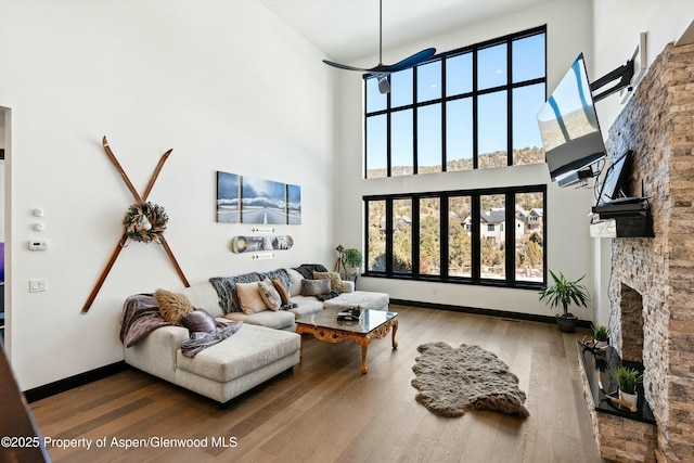 living room with a high ceiling, hardwood / wood-style floors, and a fireplace