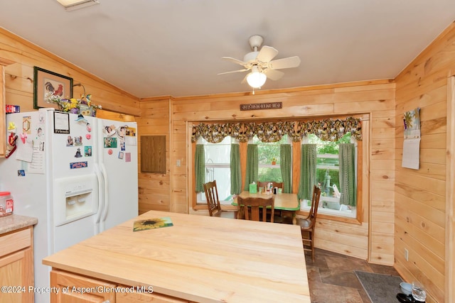kitchen with ceiling fan, wood walls, white refrigerator with ice dispenser, and light brown cabinetry