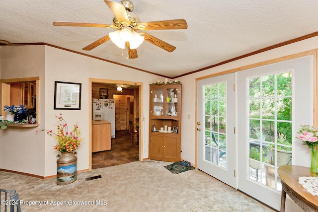 interior space with carpet flooring, a textured ceiling, vaulted ceiling, and ceiling fan