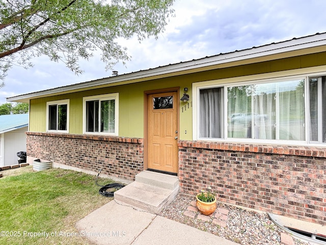 1111 Barclay St, Craig, CO 81625 - doorway to property featuring brick siding and a metal roof