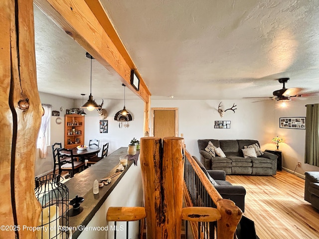 1111 Barclay St, Craig, CO 81625 - living room with wood finished floors, a ceiling fan, a textured ceiling, and beam ceiling