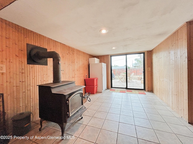 1111 Barclay St, Craig, CO 81625 - living area featuring wood walls, a wood stove, and light tile patterned floors