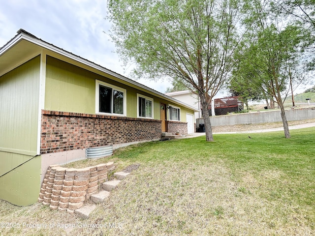 1111 Barclay St, Craig, CO 81625 - view of home's exterior featuring brick siding, a lawn, and an attached garage