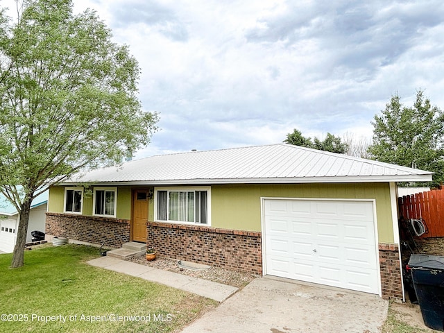 1111 Barclay St, Craig, CO 81625 - ranch-style house featuring brick siding, concrete driveway, a garage, and a metal roof