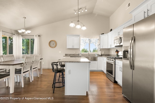 325 SE Cobblestone Ct, Cedaredge, CO 81413 - kitchen with appliances with stainless steel finishes, a chandelier, a breakfast bar area, a kitchen island, and white cabinetry