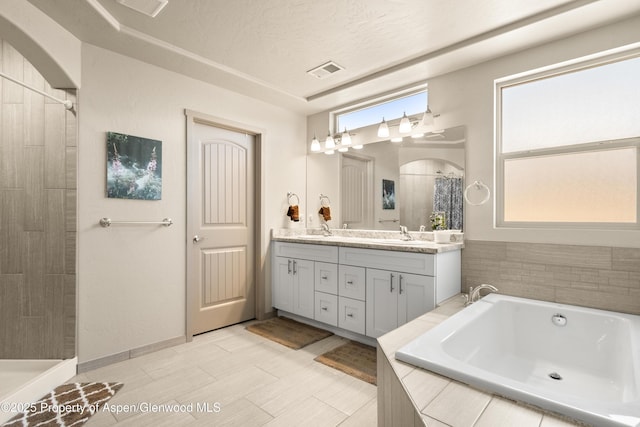 325 SE Cobblestone Ct, Cedaredge, CO 81413 - bathroom with double vanity, a bath, and a tile shower