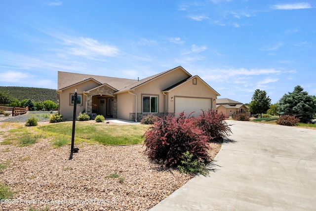 325 SE Cobblestone Ct, Cedaredge, CO 81413 - ranch-style home featuring stone siding, driveway, a garage, and stucco siding