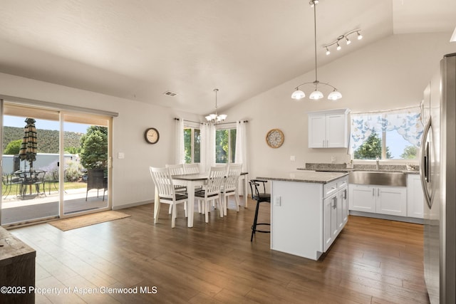 325 SE Cobblestone Ct, Cedaredge, CO 81413 - kitchen featuring vaulted ceiling, a chandelier, healthy amount of natural light, freestanding refrigerator, and a kitchen island