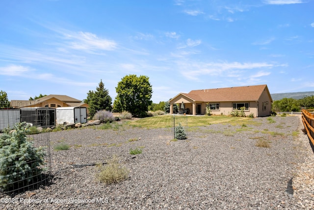 325 SE Cobblestone Ct, Cedaredge, CO 81413 - rear view of house with a storage shed and stucco siding