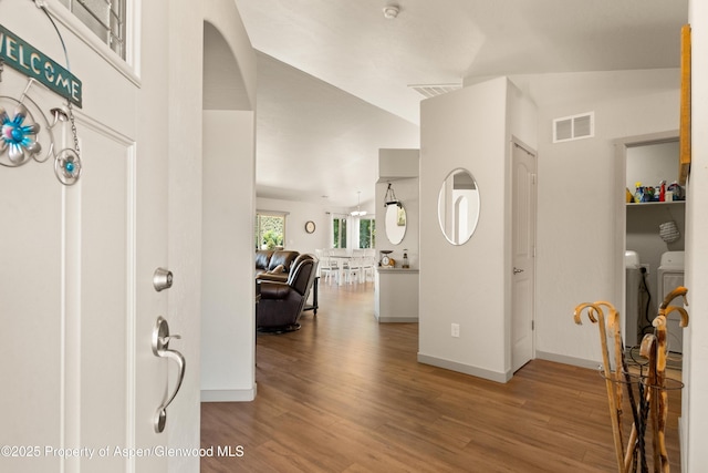 325 SE Cobblestone Ct, Cedaredge, CO 81413 - entrance foyer featuring independent washer and dryer, wood finished floors, and arched walkways