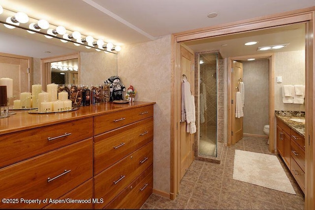 bathroom with toilet, a shower with shower door, and vanity