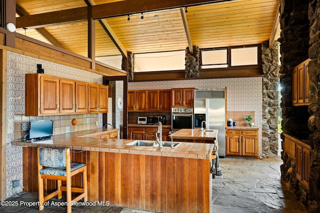 14 Fender Ln, Carbondale, CO 81623 - kitchen with wood ceiling, a peninsula, brown cabinets, oven, and high end fridge