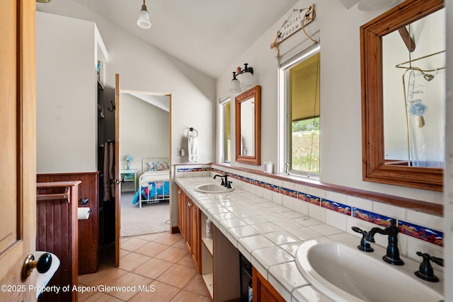 14 Fender Ln, Carbondale, CO 81623 - ensuite bathroom featuring vaulted ceiling, double vanity, tile patterned floors, a wainscoted wall, and tasteful backsplash