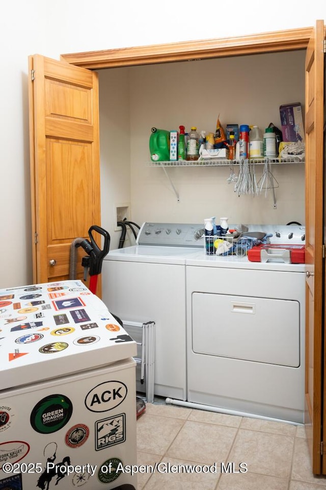 laundry area with washing machine and dryer, laundry area, and light tile patterned floors