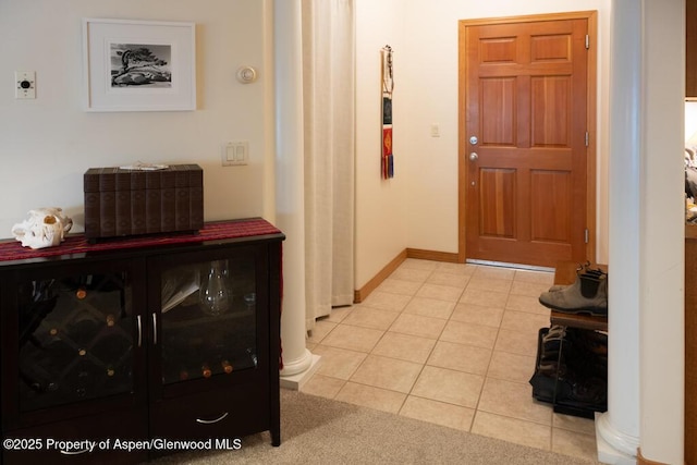 entryway with light tile patterned floors and baseboards