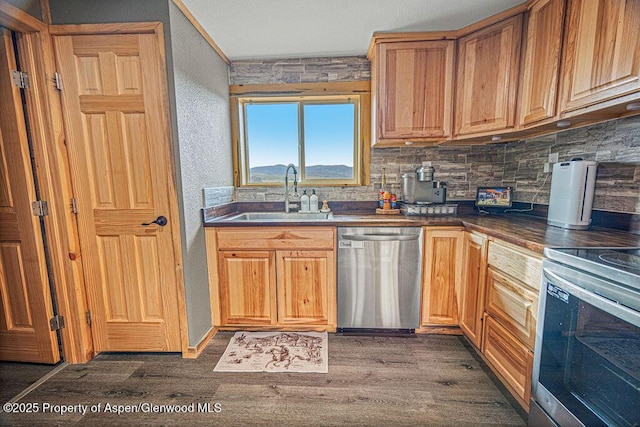 950 Highland Dr, Craig, CO 81625 - kitchen featuring decorative backsplash, a sink, dark countertops, stainless steel appliances, and dark wood-style floors