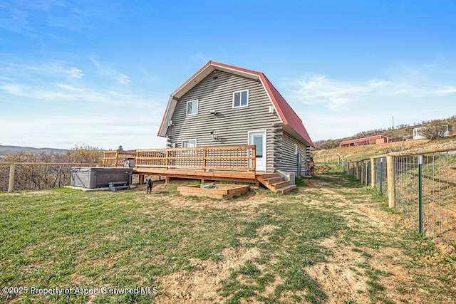 950 Highland Dr, Craig, CO 81625 - back of property featuring a lawn, a gambrel roof, a wooden deck, and a fenced backyard