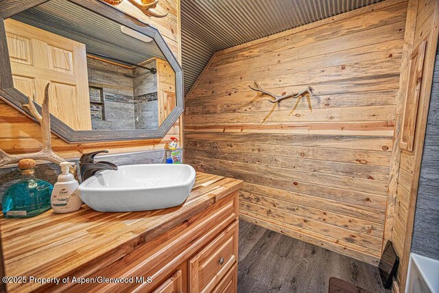 950 Highland Dr, Craig, CO 81625 - bathroom featuring wooden walls, vanity, and wood finished floors