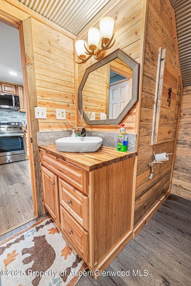 950 Highland Dr, Craig, CO 81625 - bathroom with wood finished floors, wooden walls, and vanity