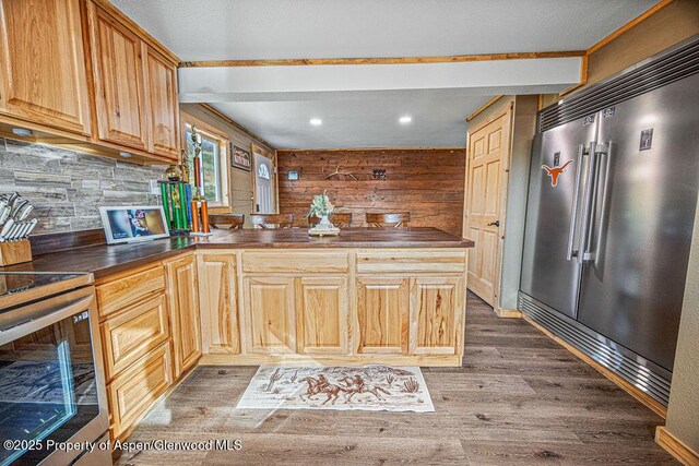 950 Highland Dr, Craig, CO 81625 - kitchen with high end refrigerator, stove, a peninsula, dark countertops, and wood finished floors