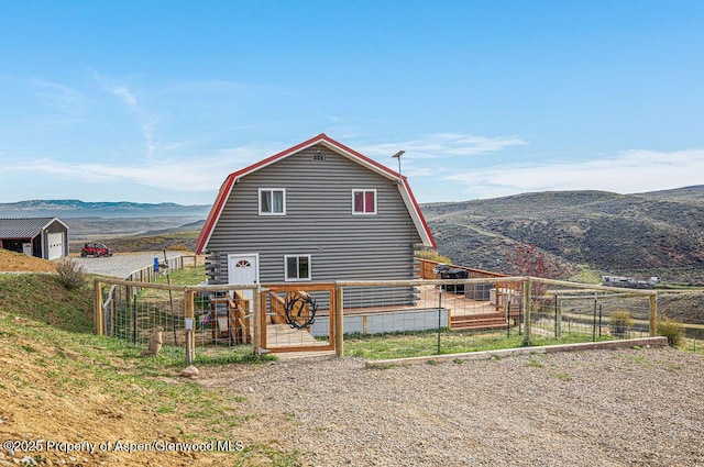950 Highland Dr, Craig, CO 81625 - back of house with a gambrel roof, a mountain view, and an outbuilding