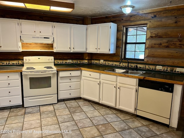 kitchen with rustic walls, sink, white cabinets, and white appliances