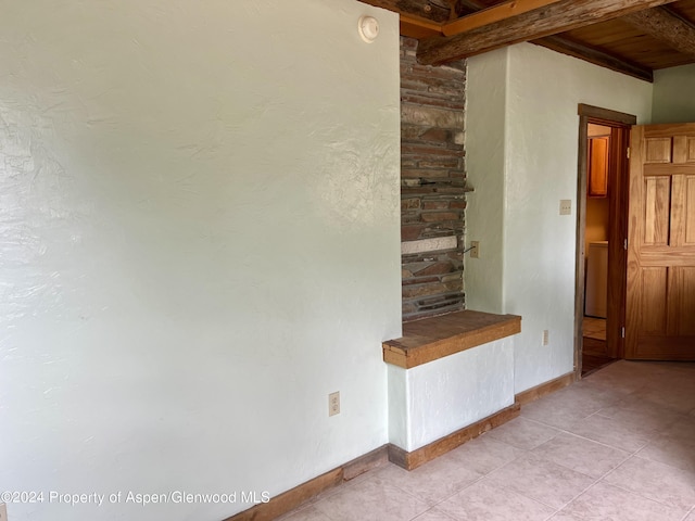 interior space featuring beamed ceiling, tile patterned flooring, and wooden ceiling