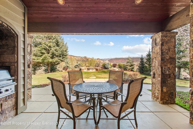view of patio featuring outdoor dining area, a mountain view, and grilling area