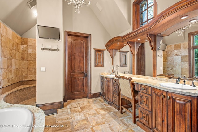 bathroom featuring a sink, vaulted ceiling, and a wealth of natural light
