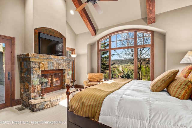 bedroom with visible vents, beamed ceiling, a stone fireplace, high vaulted ceiling, and a ceiling fan