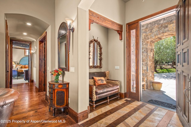 entryway featuring arched walkways, baseboards, recessed lighting, and hardwood / wood-style floors