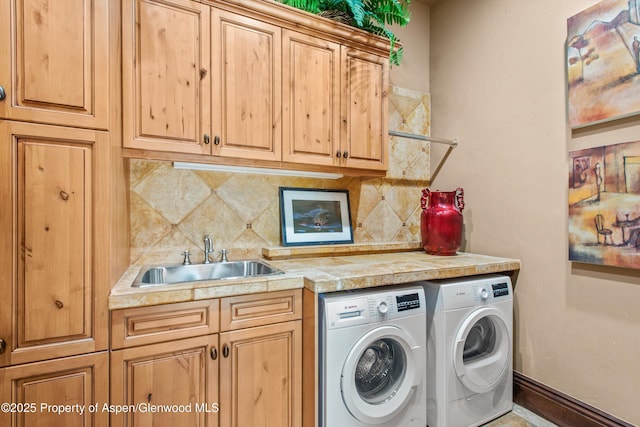 washroom with a sink, cabinet space, independent washer and dryer, and indoor wet bar