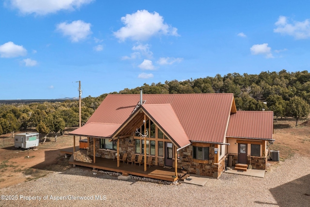 76 County Road 60b, Maybell, CO 81640 - back of house with stone siding, metal roof, central AC unit, and a view of trees