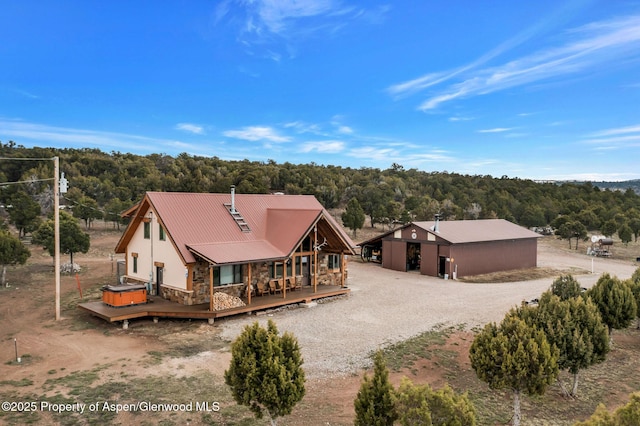 76 County Road 60b, Maybell, CO 81640 - back of house with driveway, stone siding, an outdoor structure, and a forest view