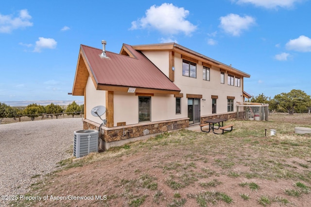 76 County Road 60b, Maybell, CO 81640 - exterior space featuring stone siding, central air condition unit, stucco siding, fence, and metal roof