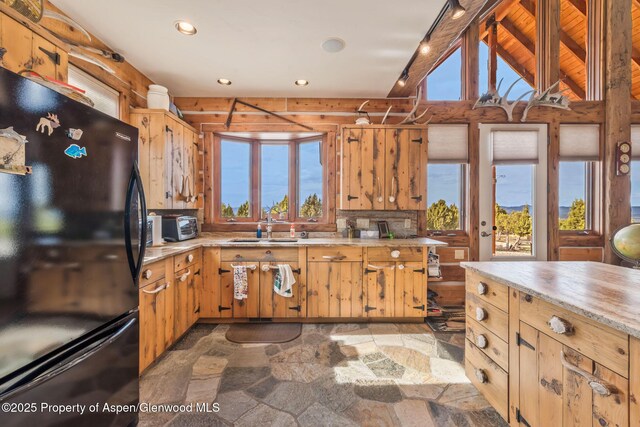 76 County Road 60b, Maybell, CO 81640 - kitchen with light countertops, vaulted ceiling with beams, a sink, freestanding refrigerator, and stone finish flooring