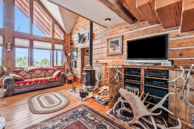 76 County Road 60b, Maybell, CO 81640 - living area featuring log walls, high vaulted ceiling, a wood stove, and wood-type flooring