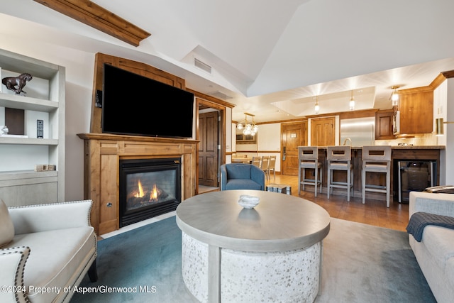 living room featuring built in shelves, lofted ceiling, and a notable chandelier