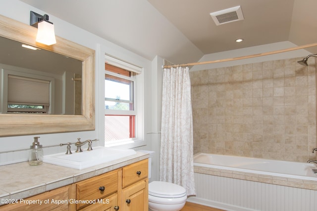 full bathroom with shower / tub combo with curtain, vanity, lofted ceiling, and toilet