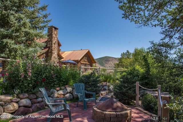 view of patio / terrace with a fire pit and a mountain view