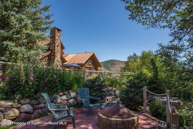 1150 Capitol Creek Rd, Snowmass, CO 81654 - view of patio / terrace with an outdoor fire pit and a mountain view